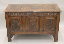 An 18th century carved oak three-panel coffer. 107.5 cm long.