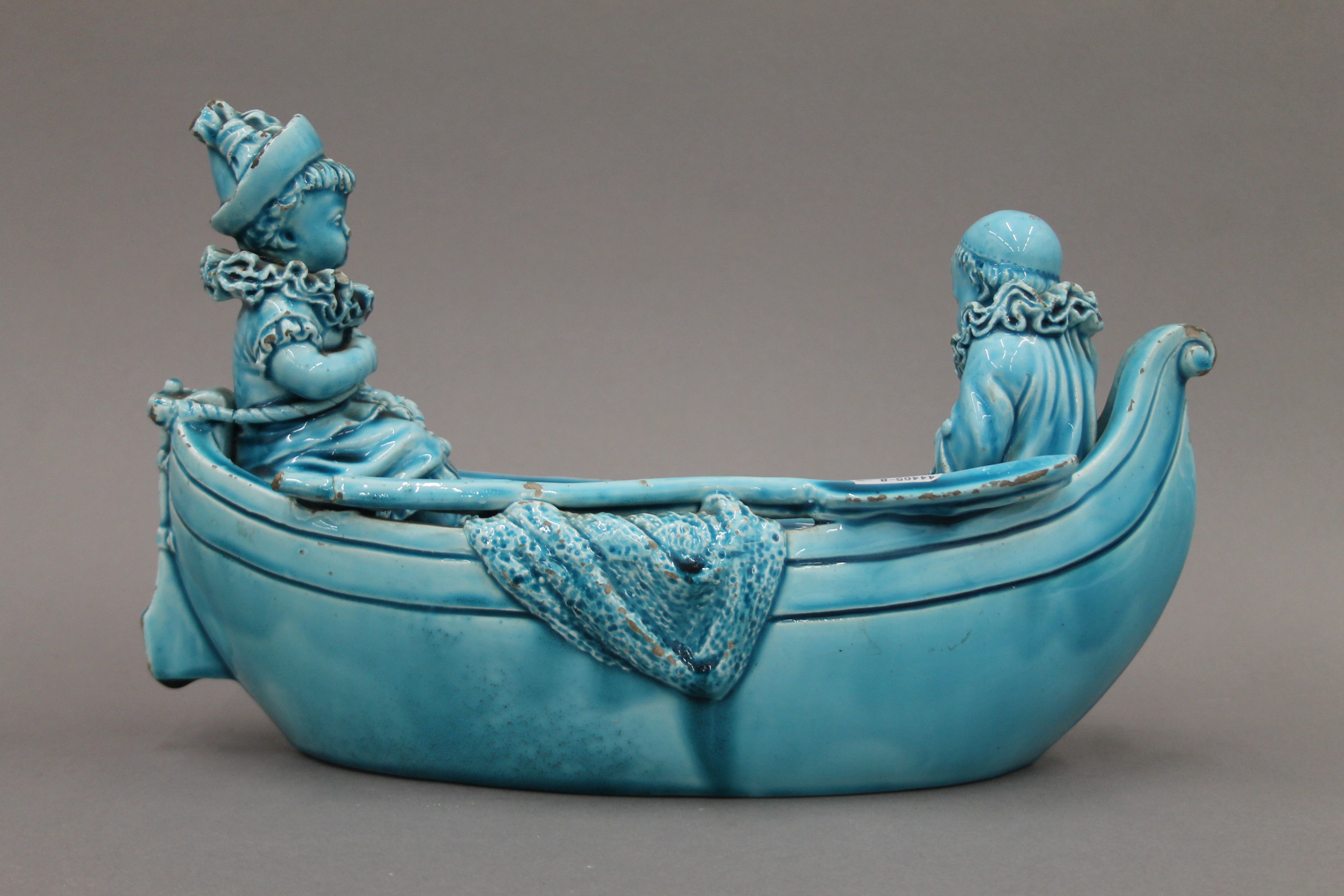 A 19th century blue ground pottery centrepiece formed as clowns in a boat. 31 cm long. - Image 5 of 8