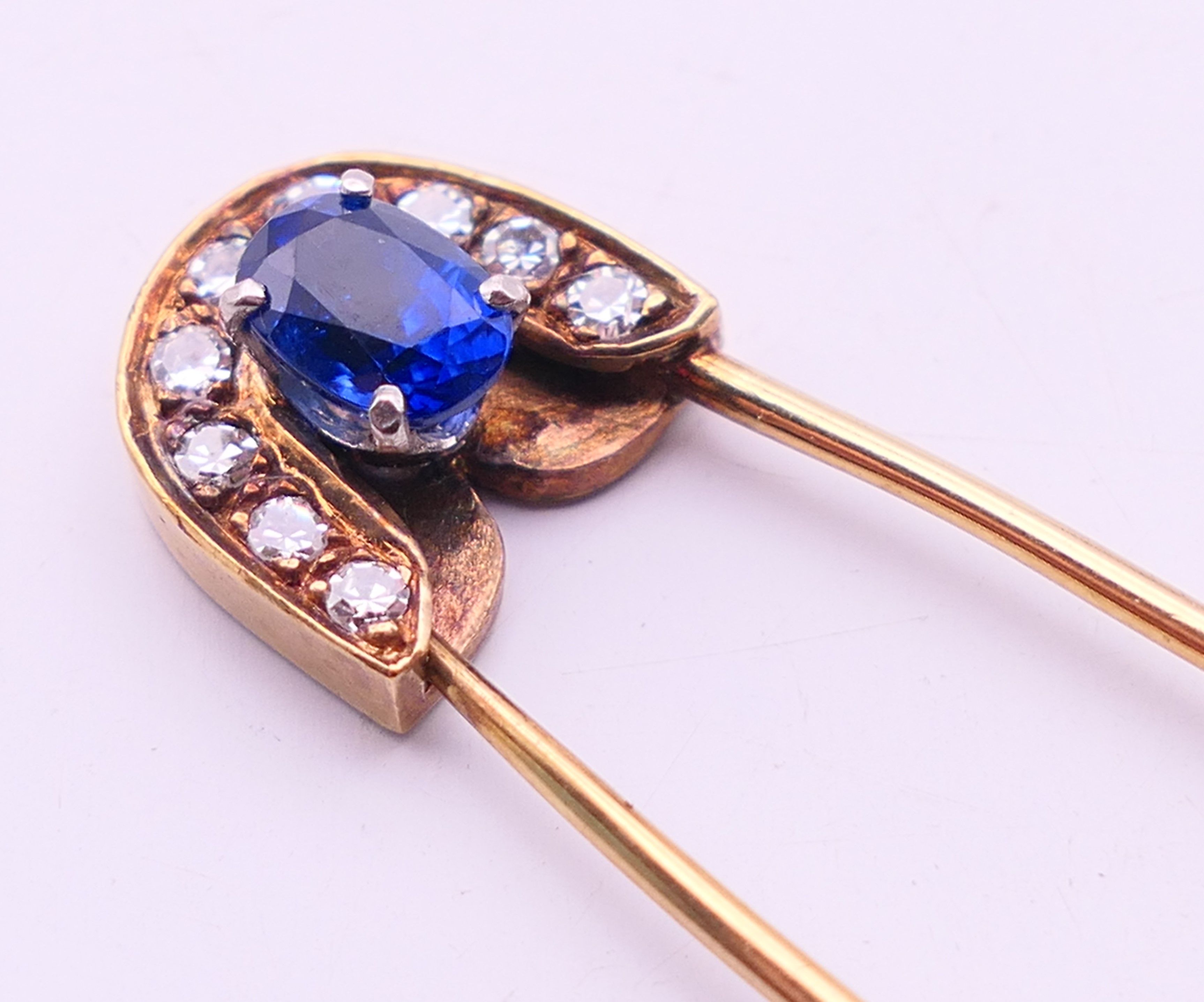 A 9 ct gold stone set safety pin form brooch. 6 cm high. 4.8 grammes total weight. - Image 2 of 6