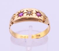 An 18 ct gold ruby and diamond ring. 3.4 grammes total weight. Ring size R/S.
