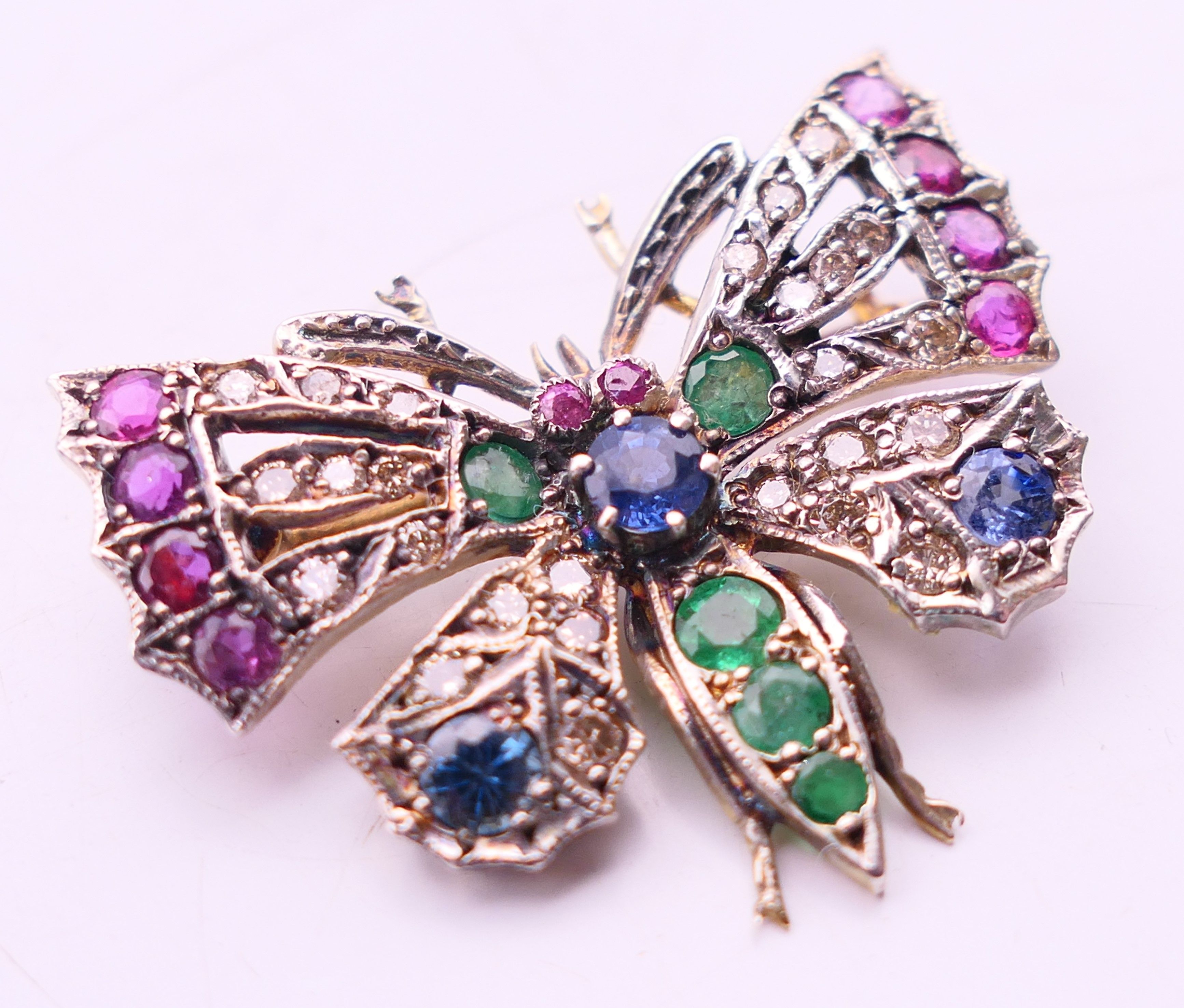 An unmarked gold multi gem set butterfly brooch. 3.5 cm x 2.75 cm. - Image 2 of 3