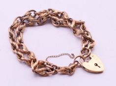 A 9 ct gold bracelet with heart padlock fastening. 19 cm long. 38 grammes.