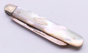 A mother-of-pearl handled silver folding fruit knife. 7 cm long closed, 11.5 cm long open.