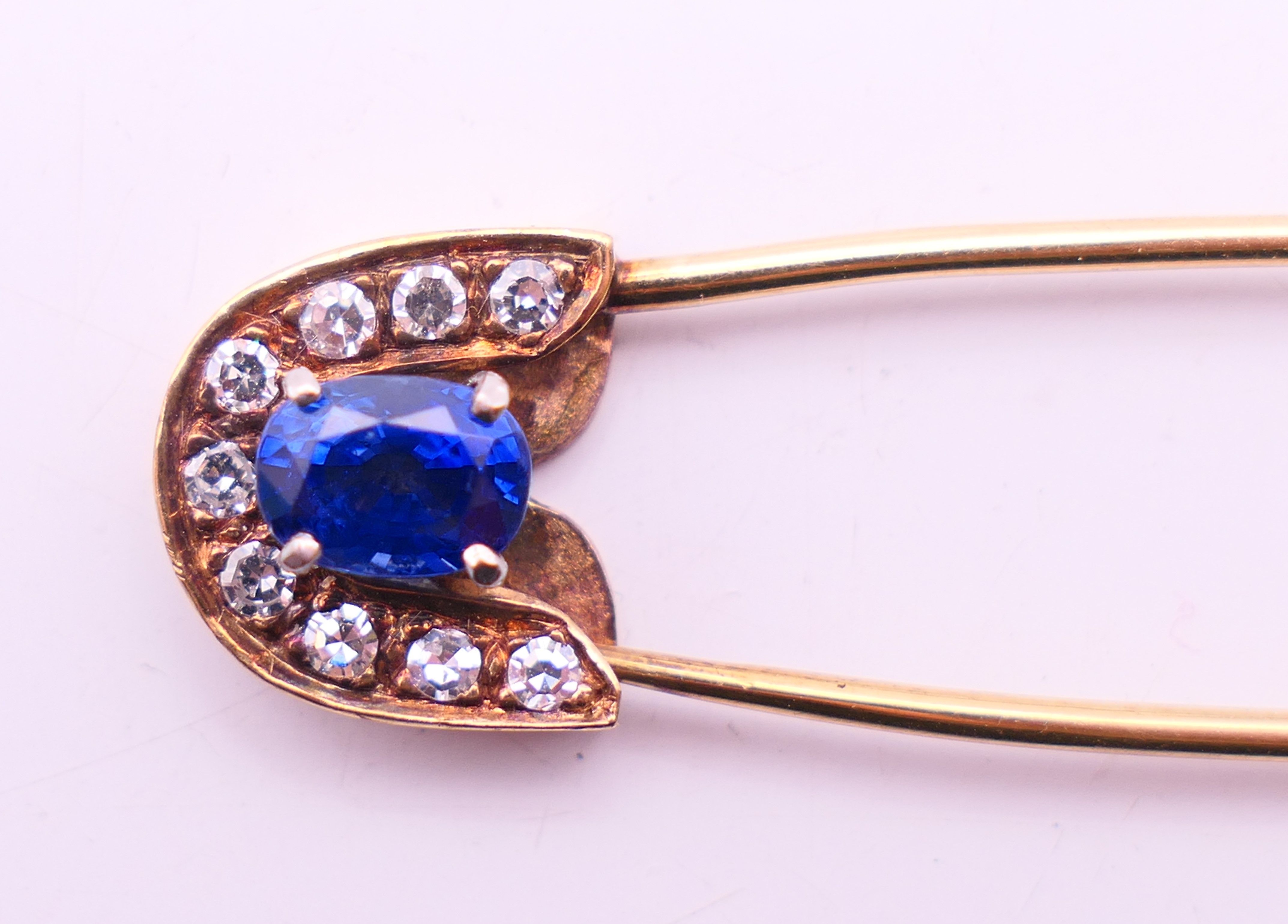 A 9 ct gold stone set safety pin form brooch. 6 cm high. 4.8 grammes total weight. - Image 4 of 6