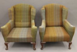 A pair of early 20th century plaid upholstered wingback armchairs. 78 cm wide.