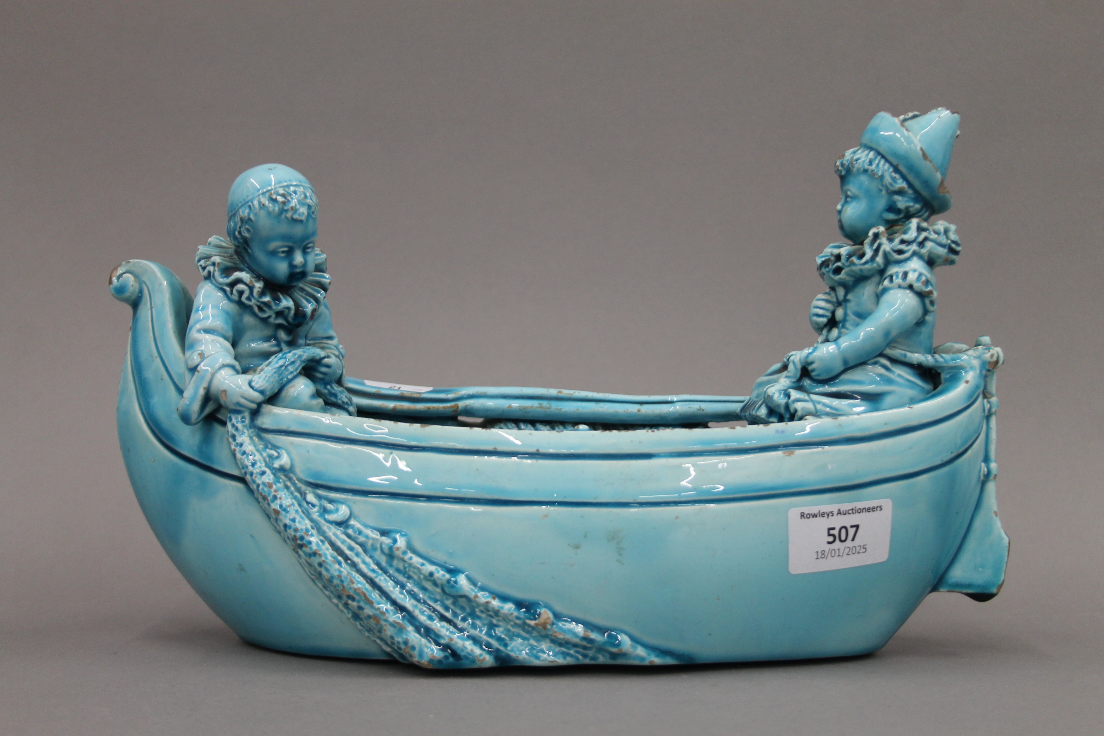 A 19th century blue ground pottery centrepiece formed as clowns in a boat. 31 cm long. - Image 2 of 8