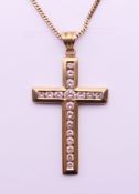 A 9 ct gold and diamond cross on a 9 ct gold chain. Cross 3.5 cm high, chain 45 cm long.