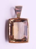 A contemporary silver, 9 ct gold and citrine pendant. 3 cm high including suspension loop.