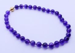 An amethyst bead necklace with 9 ct gold clasp. 46 cm long.
