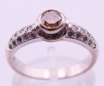 An 18 ct white gold and cinnamon diamond ring with diamond set shoulders. Ring size N.