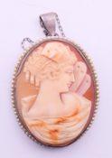 A silver and seed pearl set cameo pendant on a chain. Cameo 5 cm high, chain 40 cm long.