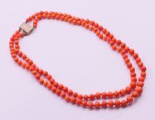 A double strand coral necklace with silver clasp. Approximately 41 cm long.