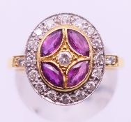 An 18 ct gold, diamond and ruby target ring. Ring size P.