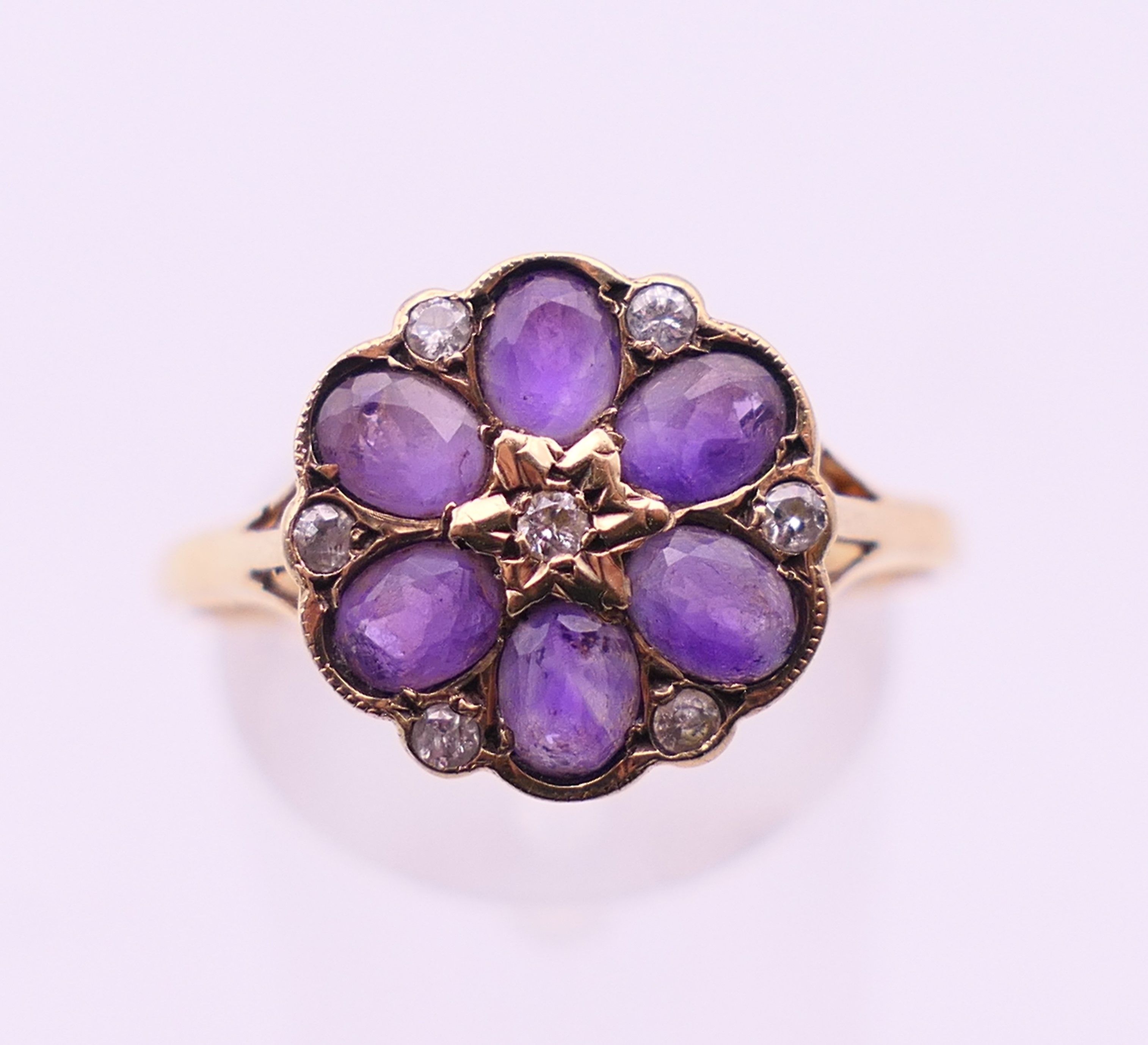 A 9 ct gold, amethyst and diamond cluster ring. Ring size U.