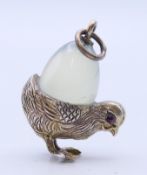 A silver and jade chick and egg pendant. 2.5 cm high.