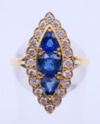 An unmarked gold, diamond and sapphire ring. Ring size P.
