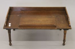 An early 20th century bed table. 63 cm wide.