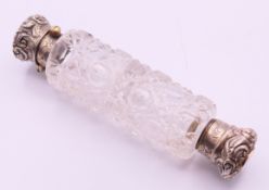 A Victorian double-ended cut glass scent bottle with silver tops. 12 cm high.
