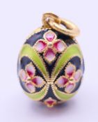 A silver and enamel pendant formed as an egg. 2 cm high.