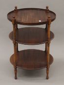 A mahogany circular three-tier whatnot. 65 cm high.