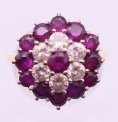 An 18 ct gold, diamond and ruby cluster ring. Ring size P.