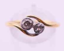 A gold and diamond two-stone crossover ring. Ring size S.