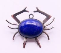 A silver and lapiz lazuli brooch formed as a crab. 3.5 cm x 3 cm.