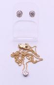 A pair of 18 ct white gold and diamond stud earrings, and a matching pendant on an 18 ct gold chain.
