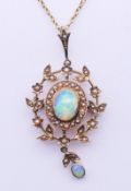 An Edwardian 9 ct gold, opal and seed pearl pendant on a 9 ct gold chain.