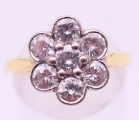 An 18 ct gold diamond flower head ring. Ring size P/Q.