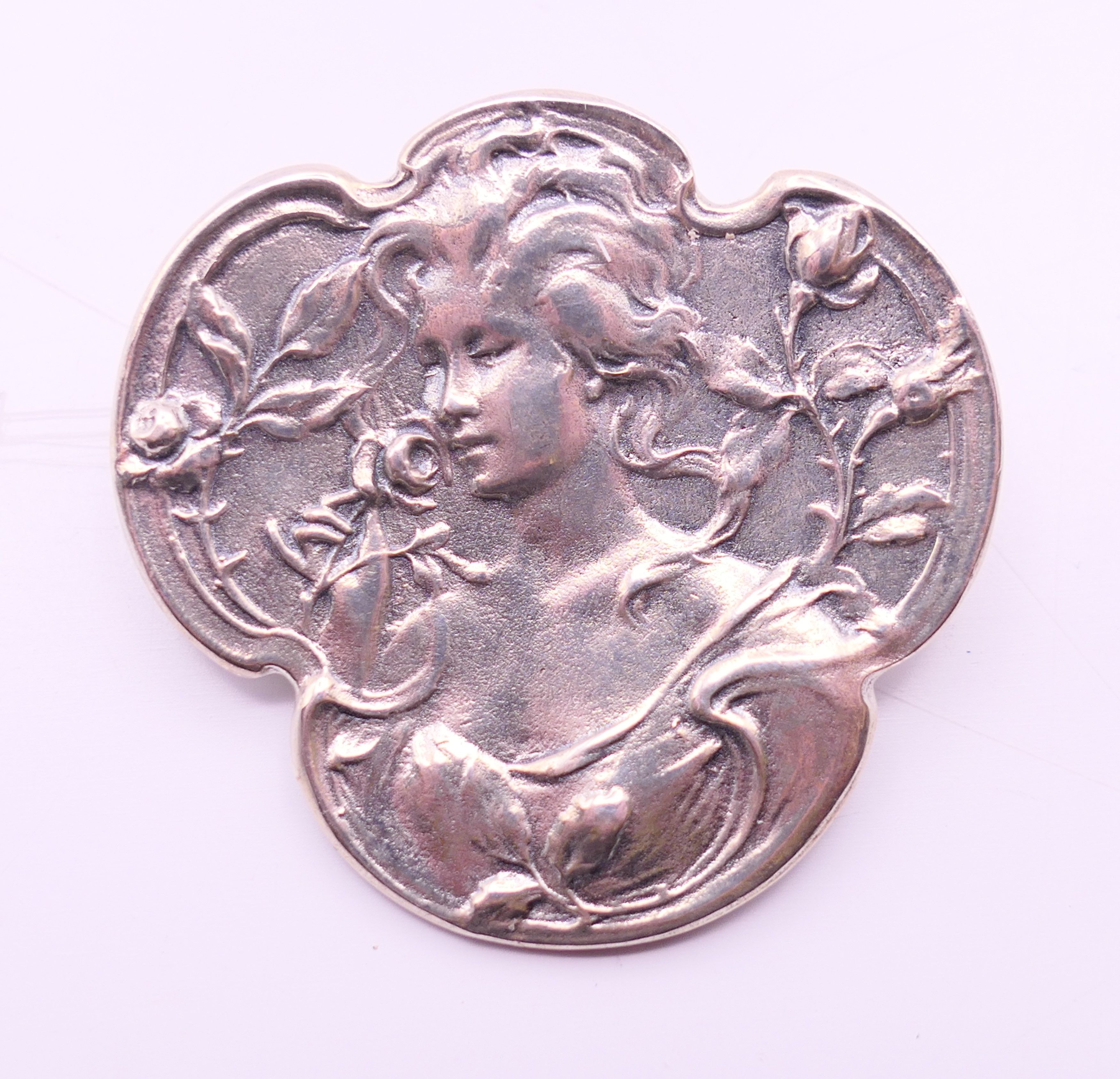An Art Nouveau-style girl brooch. 3 cm high.