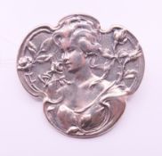 An Art Nouveau-style girl brooch. 3 cm high.