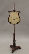 A 19th century mahogany pole screen. 141 cm high.
