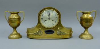A brass mantle clock and a pair of vases. The former 27.5 cm high.