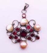 A silver, pearl and garnet pendant. 6 cm high x 5.5 cm wide.