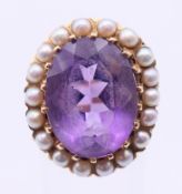 An unmarked gold, amethyst and seed pearl ring. Ring size J/K.