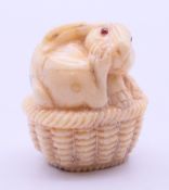 A bone netsuke formed as a rabbit/hare. 4 cm high.