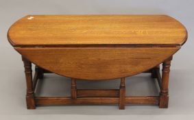 An oak drop-leaf coffee table. 115 cm long.