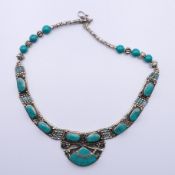 A Tibetan white metal and turquoise necklace. Approximately 45 cm long.