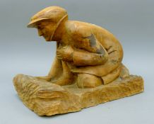 A carved wooden figure of a man holding binoculars. 40 cm long.