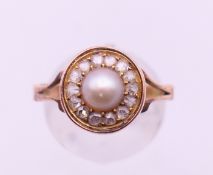 An unmarked 9 ct gold, pearl and diamond ring. Ring size R/S.