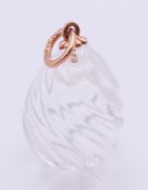 A 14 ct gold and rock crystal pendant formed as an egg. 2 cm high.
