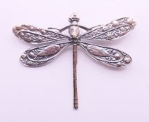 A silver dragonfly brooch. 4 cm x 5 cm.