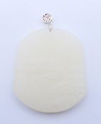A silver-topped white jade pendant. 6 cm high including suspension loop.