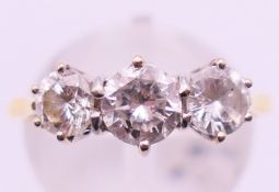 An 18 ct gold three stone diamond ring. Ring size P.