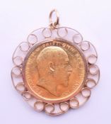 An Edward VII 1909 gold sovereign in a 9 ct gold mount. 3 cm diameter. 11.5 grammes.