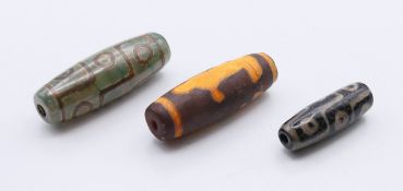 Three agate dzi beads. 4.2 cm, 4 cm and 3 cm high respectively.