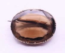 An unmarked gold and smoky quartz brooch. 2 cm x 1.5 cm.