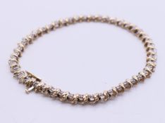 A 9 ct gold diamond set line bracelet. 19 cm long. 6.9 grammes total weight.