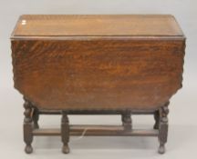 An early 20th century oak piecrust-topped barley twist gateleg table. 43 cm wide with flaps down.